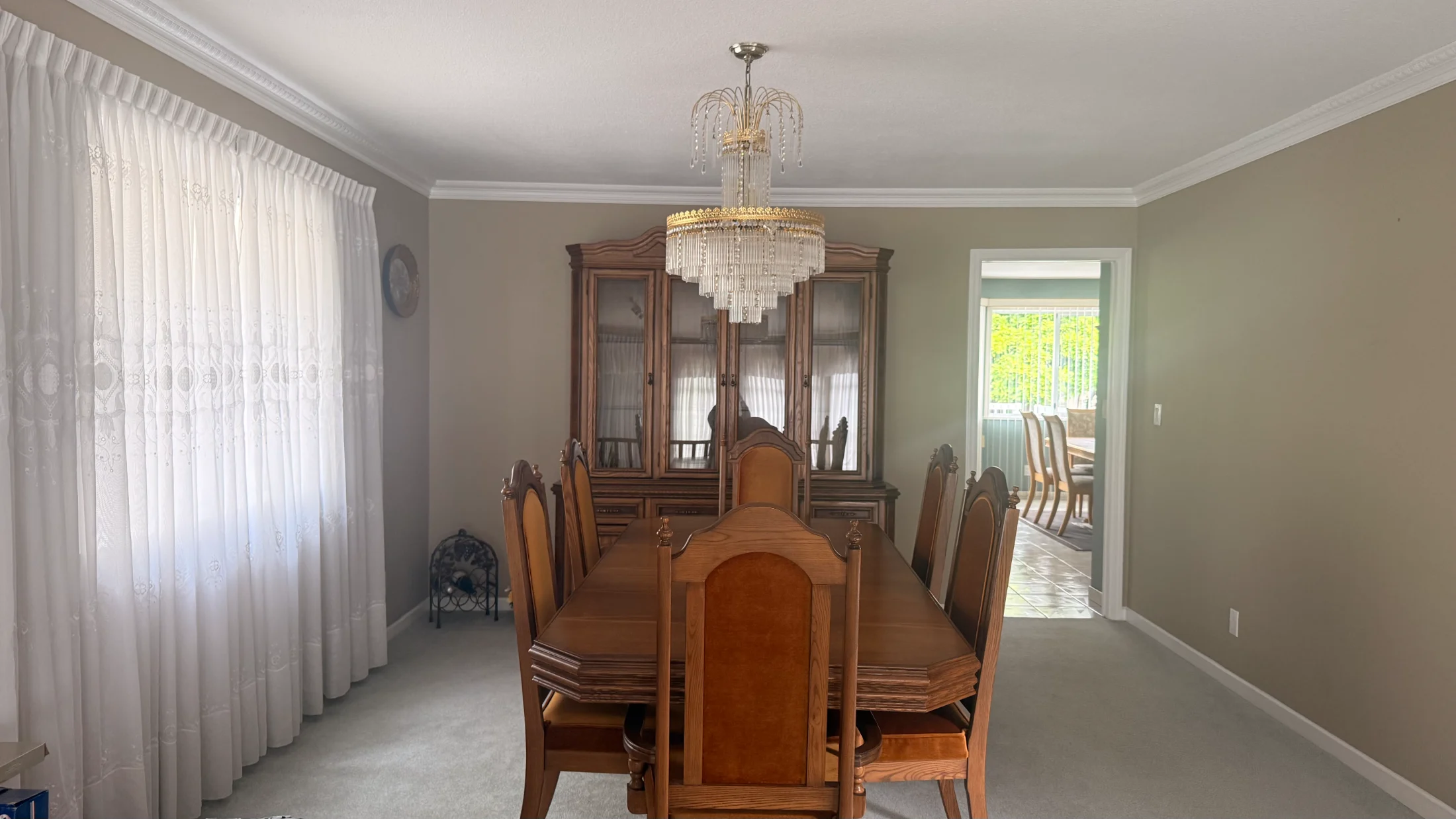 Dining room before staging: dark oak table and china cabinet